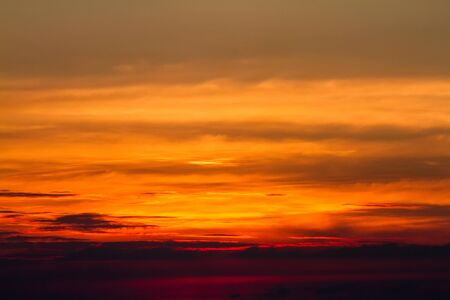 Sunset in clouds over red sunset sky background