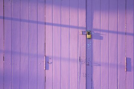 Wooden purple door with lock in the morningの写真素材