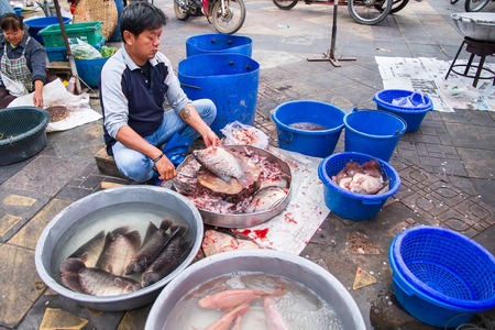Uthai Thani, Thailand - December, 17, 2016 : Unidentified Fishmonger fresh is cleaning fish for customer on street market in the morning at Uthai Thani, Thailand.のeditorial素材