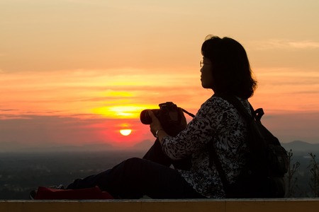 Uthai Thani, Thailand - December, 17, 2016 : Unidentified Silhouette of photographer taking pictures with camera in sunset sky at Wat Sangkat Rattana Khiri on Khao Sakae Krang mountain in Uthai Thani, Thailandのeditorial素材