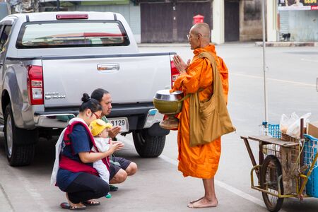 Uthai Thani, Thailand - December, 17, 2016 : Unidentified monks receive food offering from people in the morning market.Offering food is one of most common rituals in Buddhism.のeditorial素材