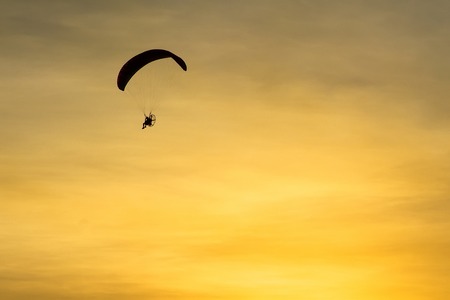 Silhouette Paramotor, Parachute, Paraglide flying in the sunset sky.の写真素材