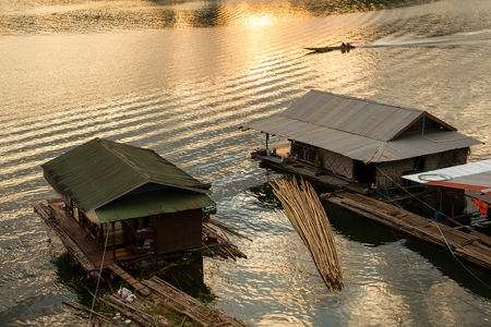Silhouette of Boating Man boat ride in the river at sunset in Sangkhlaburi ,Thailandの写真素材