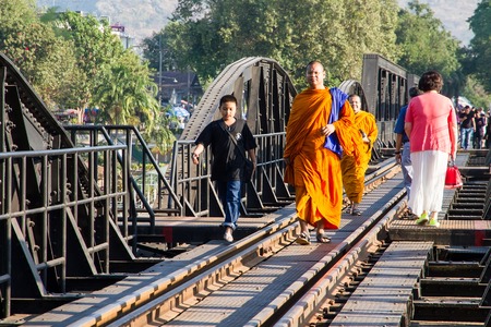 Kanchanaburi, Thailand - December, 25, 2016 : Unidentified Monk walk on The Railway Bridge on the River Kwai at Kanchanaburi,Thailand.This bridge is famous for its history in second world war.