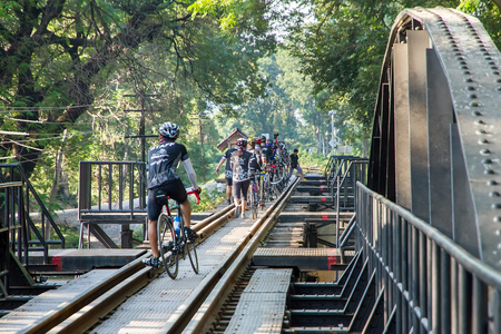 Kanchanaburi, Thailand - December, 25, 2016 : Unidentified Cyclists Tourist walk on The Railway Bridge on the River Kwai at Kanchanaburi,Thailand.This bridge is famous for its history in second world war.