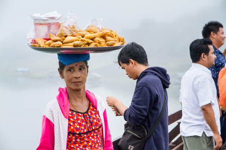 Kanchanaburi, Thailand - December, 26, 2016 : Unidentified asian women selling fried snack on the wooden bridge over the river in morning with fog and veil of mist at Sangkhlaburi, Thailandのeditorial素材