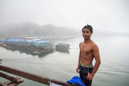 Kanchanaburi, Thailand - December, 26, 2016 : Unidentified Young boy jumping into river from wooden bridge (Mon Bridge) at Sangkhlaburi, Mon Bridge is the longest bridge in Thailand.のeditorial素材
