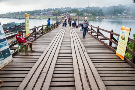 Kanchanaburi,Thailand-December,26,2016:Unidentified Tourist walk on the wooden bridge over the river in morning with fog and veil of mist at Sangkhlaburi, Mon Bridge is the longest bridge in Thailandのeditorial素材