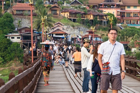 Kanchanaburi, Thailand - December, 25, 2016 : Unidentified Tourist walk on the wooden bridge (Mon Bridge) over the river in sunset at Sangkhlaburi, Mon Bridge is the longest bridge in Thailandのeditorial素材