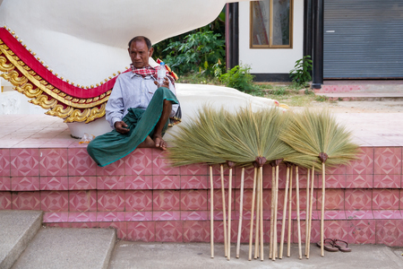 Kanchanaburi, Thailand - December, 26, 2016 : Unidentified Man dressed native sell broom at Bodhgaya Stupa or Phuthakaya Pagoda at Sangklaburi, Kanchanaburi, Thailand.のeditorial素材