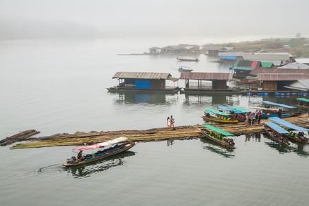 Kanchanaburi, Thailand - December, 26, 2016 : Top view of the House floating port boat tour on the wooden bridge (Mon Bridge) over the river in morning fog and mist at Sangkhlaburi, Mon Bridge is the longest bridge in Thailandのeditorial素材