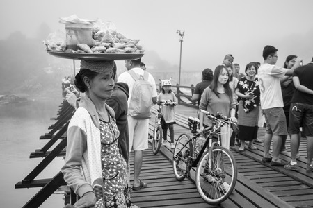 Kanchanaburi, Thailand - December, 26, 2016 : Unidentified asian women selling fried snack on the wooden bridge over the river in morning with fog and veil of mist at Sangkhlaburi, Thailandのeditorial素材