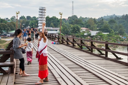 Kanchanaburi, Thailand - December, 25, 2016 : Unidentified Tourist walk on the wooden bridge (Mon Bridge) over the river in sunset at Sangkhlaburi, Mon Bridge is the longest bridge in Thailandのeditorial素材