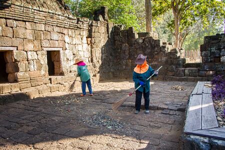Kanchanaburi, Thailand - December, 25, 2016 : Gardener sweeping leaves at ancient thai castle or Prasat Muang Singh in Kanjanaburi , Thailand.のeditorial素材
