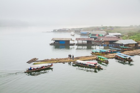 Kanchanaburi, Thailand - December, 26, 2016 : Top view of the House floating port boat tour on the wooden bridge (Mon Bridge) over the river in morning fog and mist at Sangkhlaburi, Mon Bridge is the longest bridge in Thailandのeditorial素材