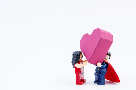 Nonthaburi, Thailand - January, 09, 2017 : Lego super man showing love give a paper box red heart shape to lego super woman on white background.Concept Valentine's Dayのeditorial素材
