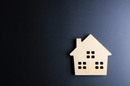 Wooden house toy on black background with copy space.Real estate concept, New house concept, Finance loan business conceptの写真素材