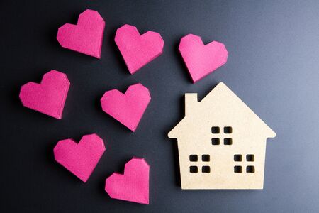 Wooden house toy and paper box red heart shape on black background with copy space.Real estate concept, New house concept, Love house concept, Finance loan business conceptの写真素材
