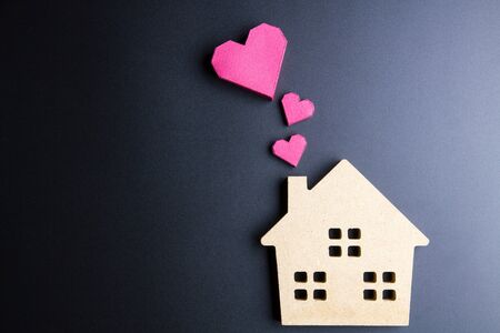 Wooden house toy and paper box red heart shape on black background with copy space.Real estate concept, New house concept, Love house concept, Finance loan business conceptの写真素材