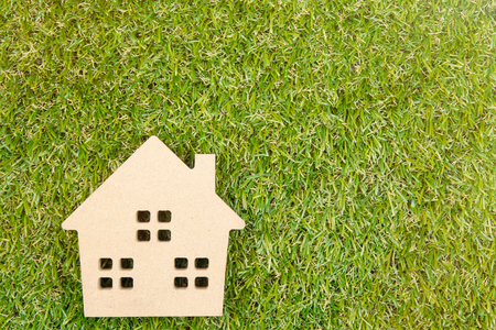 Wooden house toy on ground green grass with copy space.Real estate concept, New house concept, Love house concept, Finance loan business conceptの写真素材
