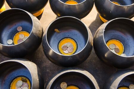 Inserting a coin into the bowl Belief in Buddhismの写真素材