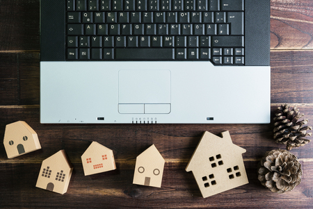 Top view of office stuff with laptop and Wooden house toy on wooden table.Concept workplace.Real estate concept, New house concept, Finance loan business conceptの写真素材