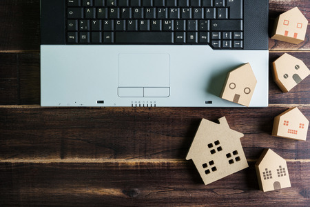 Top view of office stuff with laptop and Wooden house toy on wooden table.Concept workplace.Real estate concept, New house concept, Finance loan business conceptの写真素材