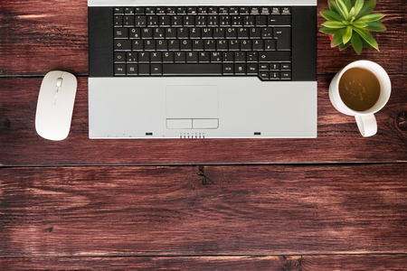 Top view of office stuff with laptop wireless mouse and coffee cup on wooden table.Concept workplaceの写真素材