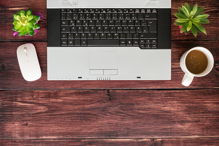 Top view of office stuff with laptop wireless mouse and coffee cup on wooden table.Concept workplaceの写真素材