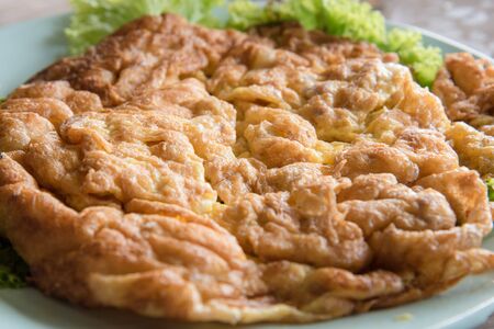 Thai fried omelet with pork on wooden tableの写真素材