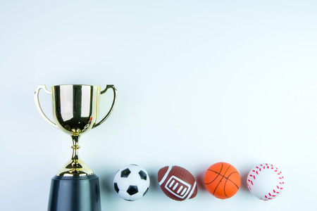 Golden trophy, Football toy, Baseball toy, Basketball toy and Rugby toy isolated on white background with copy space.Concept winner of the sportの写真素材