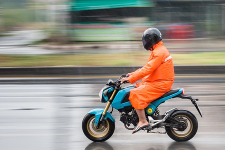 Nonthaburi, Thailand - April, 04, 2017 : Motion Blurred panning photo of Unidentified name man riding motorcycle in the rain on road at Nonthaburi, Thailand.のeditorial素材
