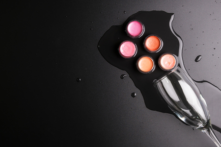 Lipstick cartridges and Wine glass isolated on black background, Cosmetics concept, Makeup concept, Copy space image for your text, Flat layの写真素材