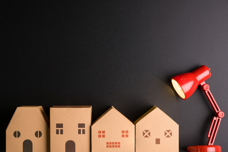 Paper house and Red lamp isolated on black background with copy space image for your text.Real estate concept, New house concept, Finance loan business conceptの写真素材