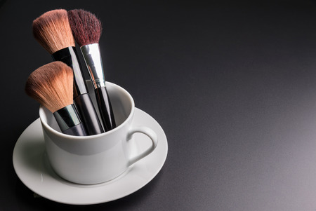 Set of flat top view of various professional female cosmetics brushes for makeup in white coffee cup isolated on black background, Cosmetics concept, Makeup concept, Copy space image for your textの写真素材
