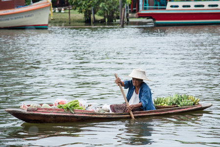 Bangkok, Thailand - April, 09, 2017 : Unidentified name old women rowing selling fruit on the boat in Taling Chan Floating Markett at Bangkok, Thailand.のeditorial素材