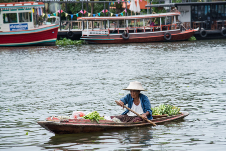 Bangkok, Thailand - April, 09, 2017 : Unidentified name old women rowing selling fruit on the boat in Taling Chan Floating Markett at Bangkok, Thailand.のeditorial素材