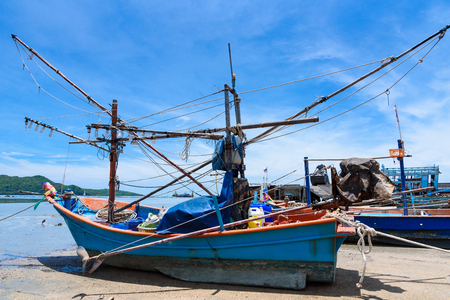 Fishing boats aground on the beach over cloudy sky at Prachuap Khiri Khan, Thailandの写真素材