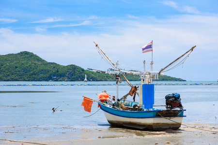 Fishing boats aground on the beach over cloudy sky at Prachuap Khiri Khan, Thailandの写真素材