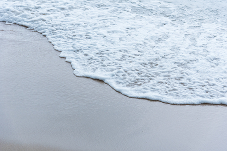 Ocean waves exhausted on the beachの写真素材