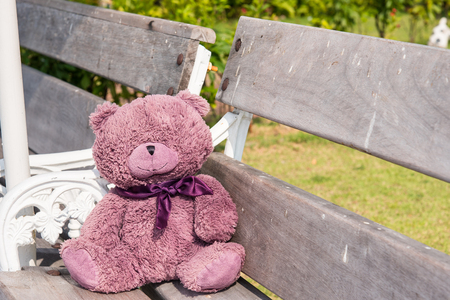 Teddy bears sitting on a wooden chairの写真素材