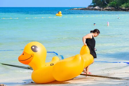 Rayong, Thailand - April, 28, 2017 : Unidentified name Female tourists are dragging Yellow Duck swim tube on the beach on the beach at the Koh Samet island, Rayong, Thailandのeditorial素材