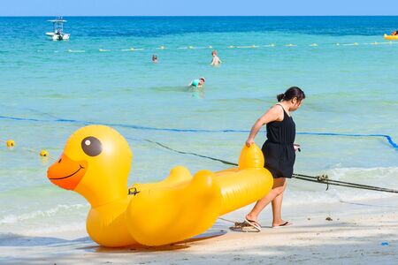 Rayong, Thailand - April, 28, 2017 : Unidentified name Female tourists are dragging Yellow Duck swim tube on the beach on the beach at the Koh Samet island, Rayong, Thailandのeditorial素材