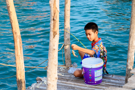 Chon Buri, Thailand - April, 27, 2017 : Unidentified name boy sitting fishing at the jetty at Sattahip, Chon Buri, Thailand.のeditorial素材