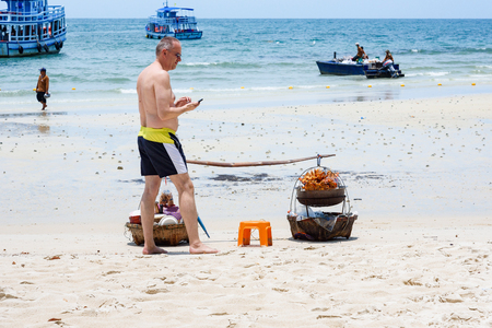 Rayong, Thailand - April, 29, 2017 : Unidentified name Foreign tourists waiting for the trader selling Somtum Grilled Chicken, Local Food on the Samet Island Beach, Rayong, Thailandのeditorial素材