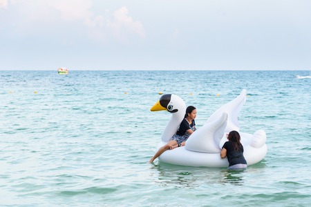 Rayong, Thailand - April, 28, 2017 : Unidentified name Tourists are playing in the sea with Inflatable whiye swan swim tube at the Koh Samet island, Rayong, Thailandのeditorial素材
