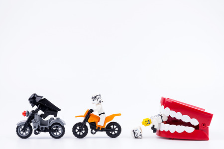 Nonthabure, Thailand - May, 17, 2017 : Lego Darth Vader and Lego stormtrooper riding a motorcycle red plastic chattering teeth being bitten isolated on white background.のeditorial素材