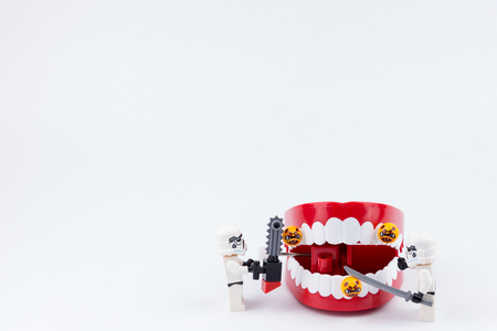 Nonthabure, Thailand - May, 17, 2017 : Lego stormtrooper helping get disinfect of bacteria on red plastic chattering teeth isolated on white background.のeditorial素材