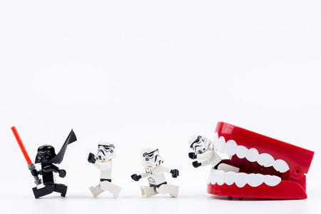Nonthabure, Thailand - May, 17, 2017 : Red Plastic chattering teeth being bitten Lego Darth Vader and Lego stormtrooper isolated on white background.のeditorial素材