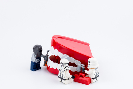 Nonthabure, Thailand - May, 17, 2017 : Lego stormtrooper helping repair the red plastic chattering teeth isolated on white background.のeditorial素材